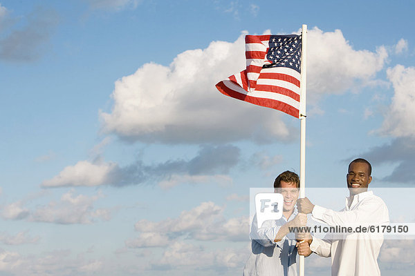 Multi-ethnic men holding American flag