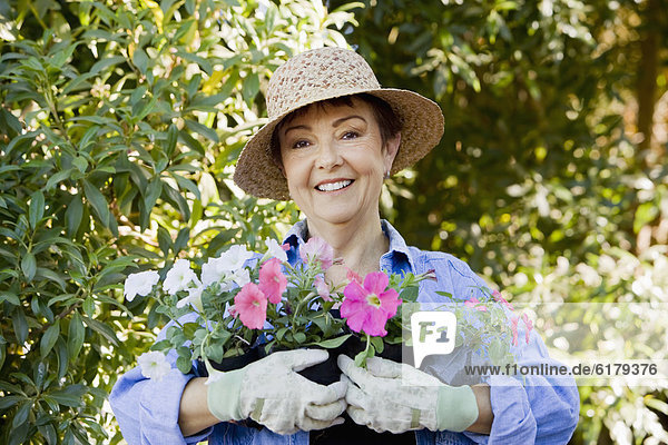 Frau Blume Hispanier halten Garten