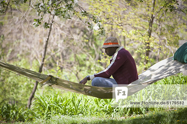 Black man sitting in hammock