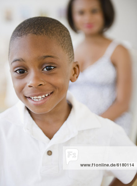 Smiling Black boy with mother in background