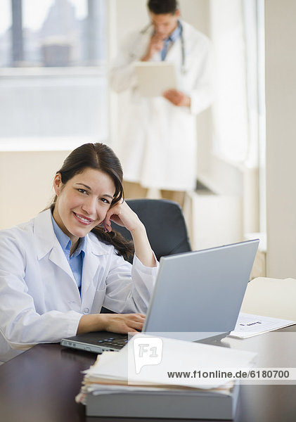 Mixed race doctor working on laptop