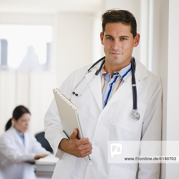Mixed race doctor holding medical record in doctor's office