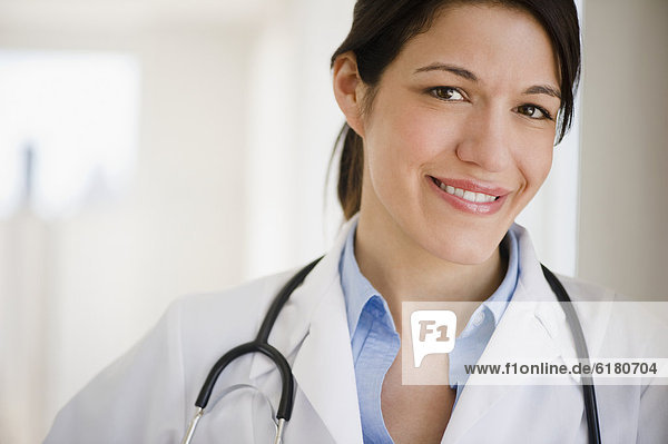 Smiling mixed race doctor in lab coat with stethoscope