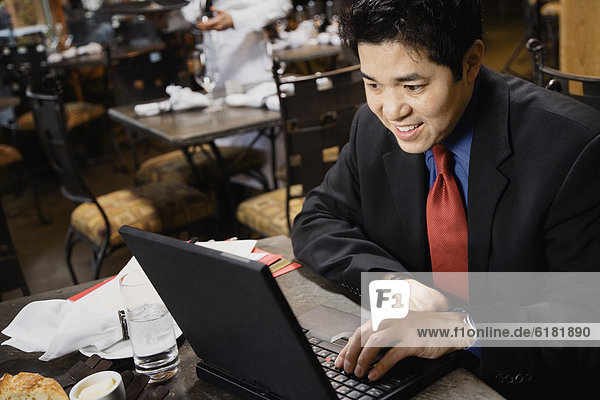 Asian businessman typing on laptop