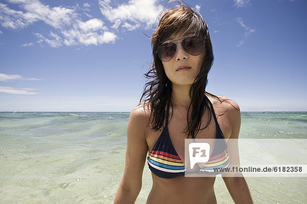 Korean woman in bikini with ocean in background