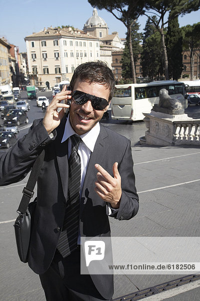 Italian businessman talking on cell phone outdoors