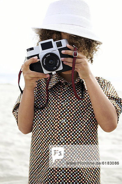 Mixed race boy using old-fashioned camera