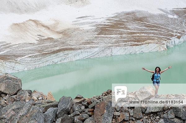Hispanic woman hiking hear glacial lake