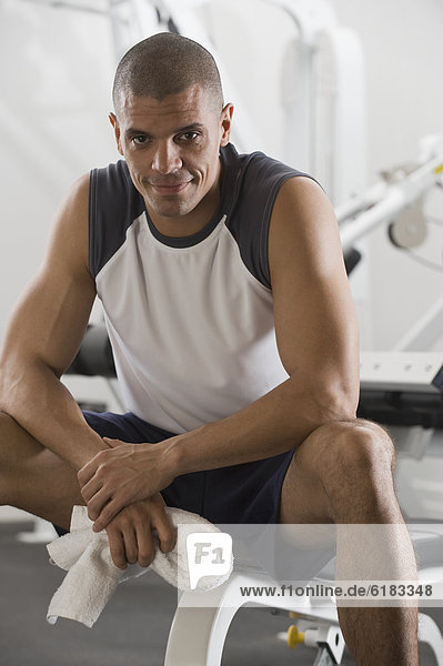 Hispanic man sitting in gym