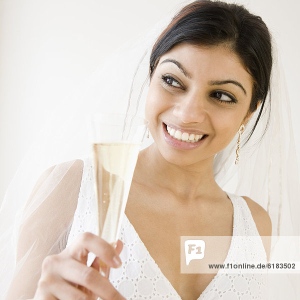 Mixed Race bride holding champagne glass