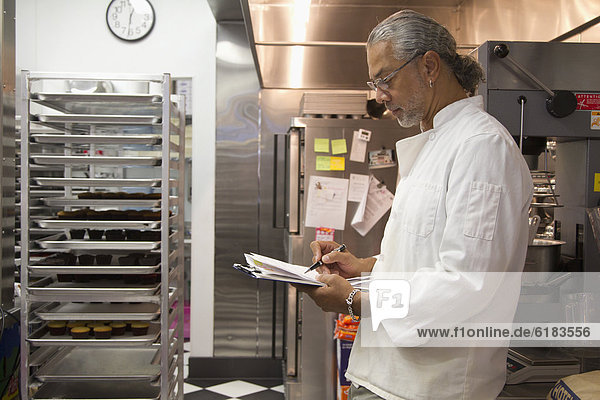 African American small business owner working in bakery kitchen