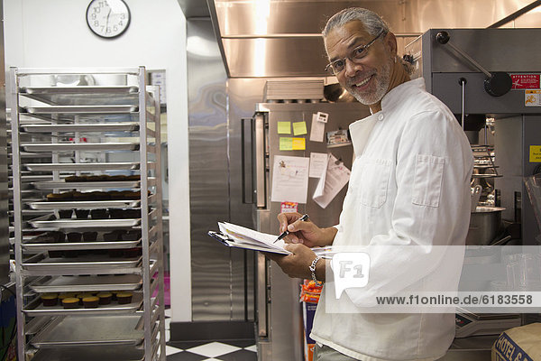 African American small business owner working in bakery kitchen