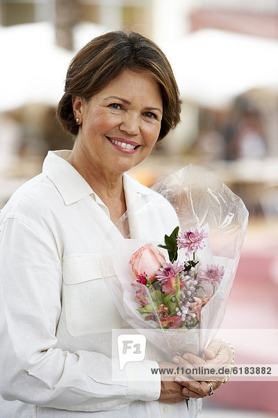 Hispanic woman holding flower bouquet