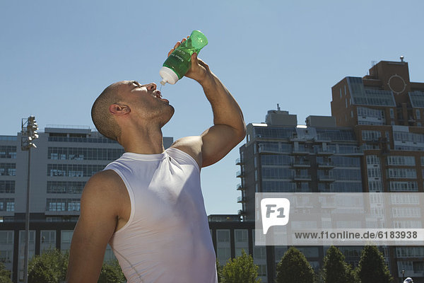 Mixed race athlete drinking water