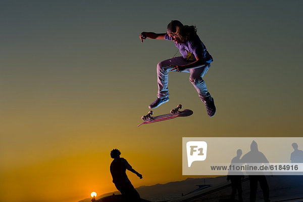 Europäer  In der Luft schwebend  Sonnenuntergang  Stunt  Skateboarder