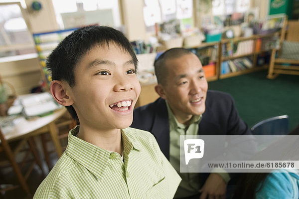 Asian son with father in classroom