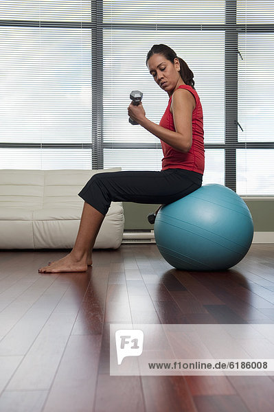 Hispanic woman exercising with hand weights