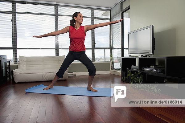 Hispanic woman exercising on yoga mat