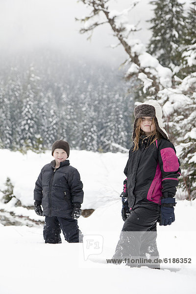 Caucasian children standing in snow
