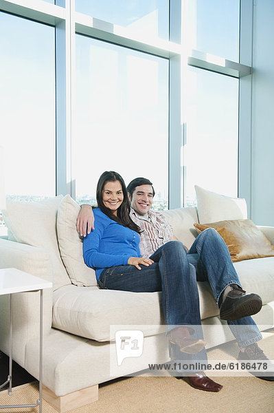 Smiling couple sitting on sofa
