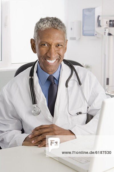 Mixed race doctor sitting at desk