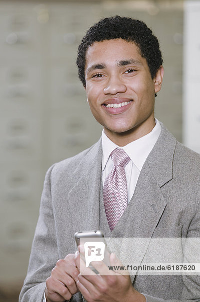 Mixed race businessman holding cell phone