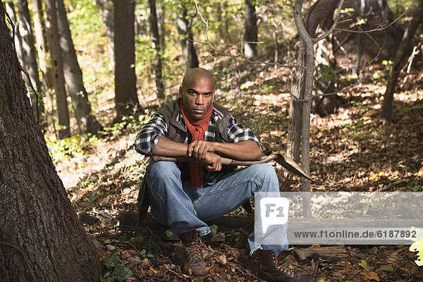 African American man sitting in woods