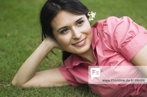 Hispanic woman laying in grass