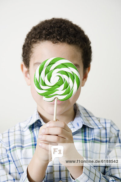 Mixed race boy with oversized lollipop