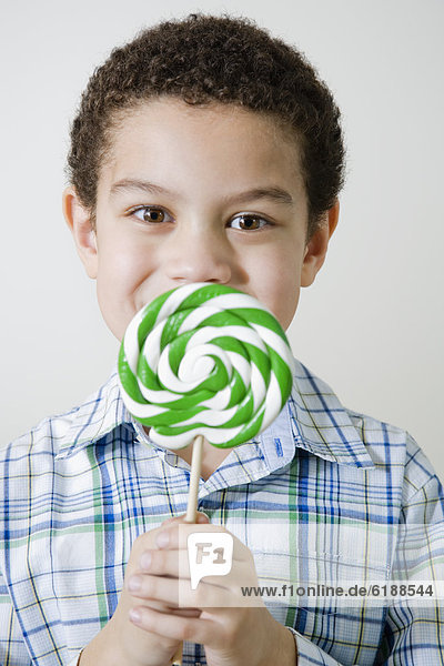 Mixed race boy with oversized lollipop