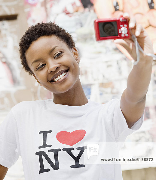 African woman taking self-portrait with digital camera