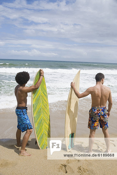 Friends at beach with surfboards