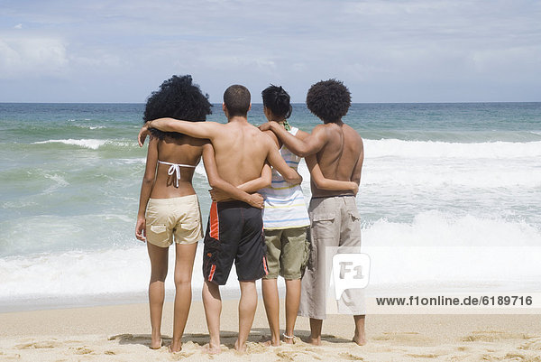 Freundschaft  umarmen  Strand  multikulturell