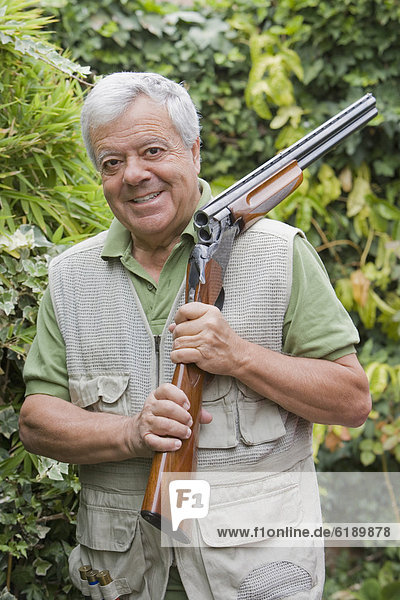 Senior Chilean man holding shotgun