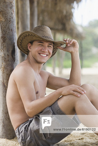 Bare chested Hispanic man in cowboy hat