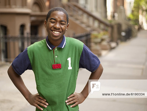 African teenage boy laughing in urban setting