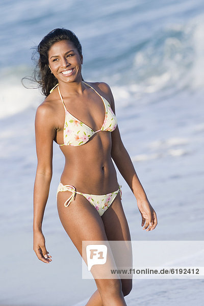 Hispanic woman in bikini at beach