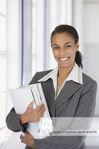 Confident African businesswoman holding paperwork