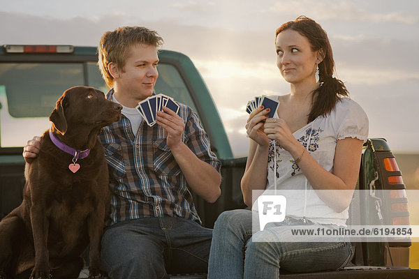 Caucasian couple playing cards in truck