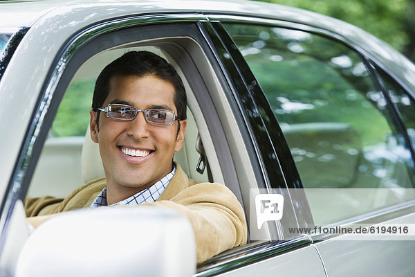 Hispanic man driving car