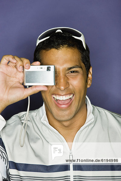 Hispanic man taking photograph with camera