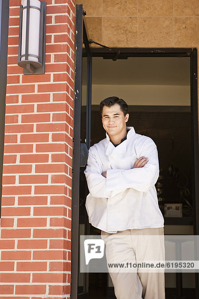 Chinese chef standing in restaurant doorway