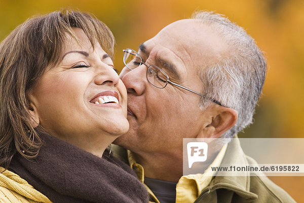Hispanic couple kissing outdoors