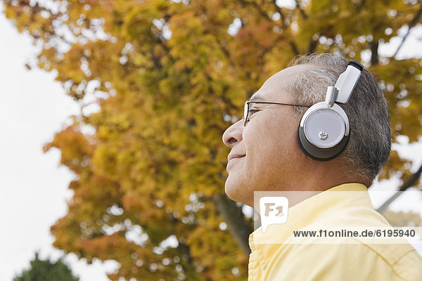 Hispanic man wearing headphones outdoors