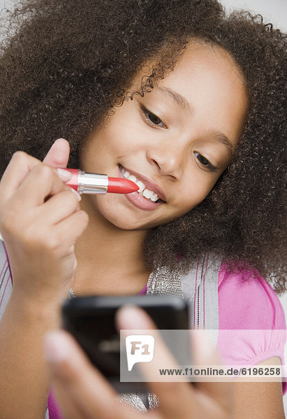 African girl applying lipstick