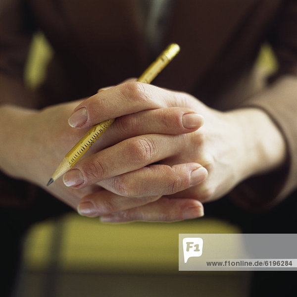 Close up of Caucasian businesswoman's hands holding pencil