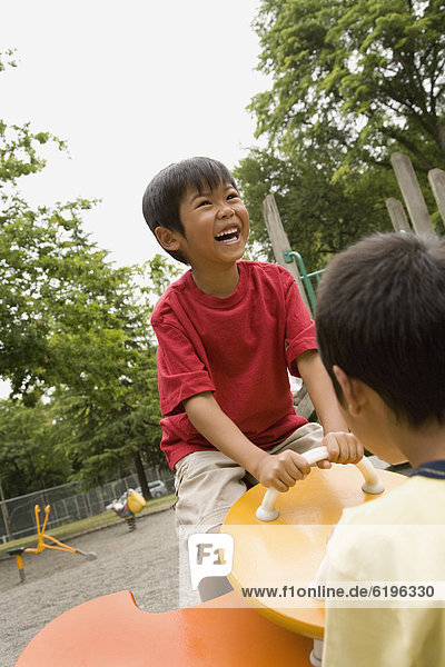 Laughing Asian boy playing on playground