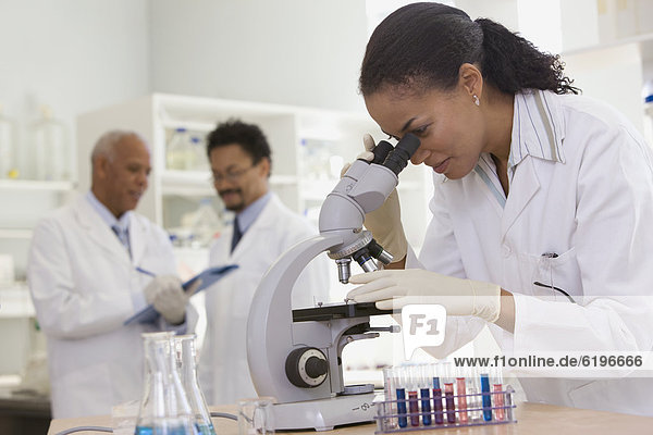 African scientist performing analysis in laboratory with microscope