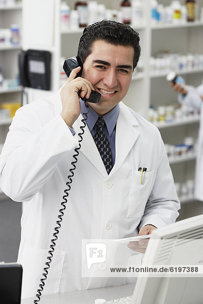 Portrait of Hispanic male pharmacist talking on telephone