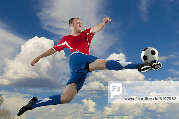 Fußballspieler Europäer In der Luft schwebend treten springen Ball Spielzeug